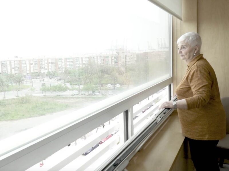 Maria Angeles intervenida de rodilla mirando por la ventana