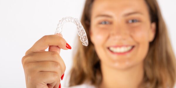 Happy young woman with invisible teeth aligner.